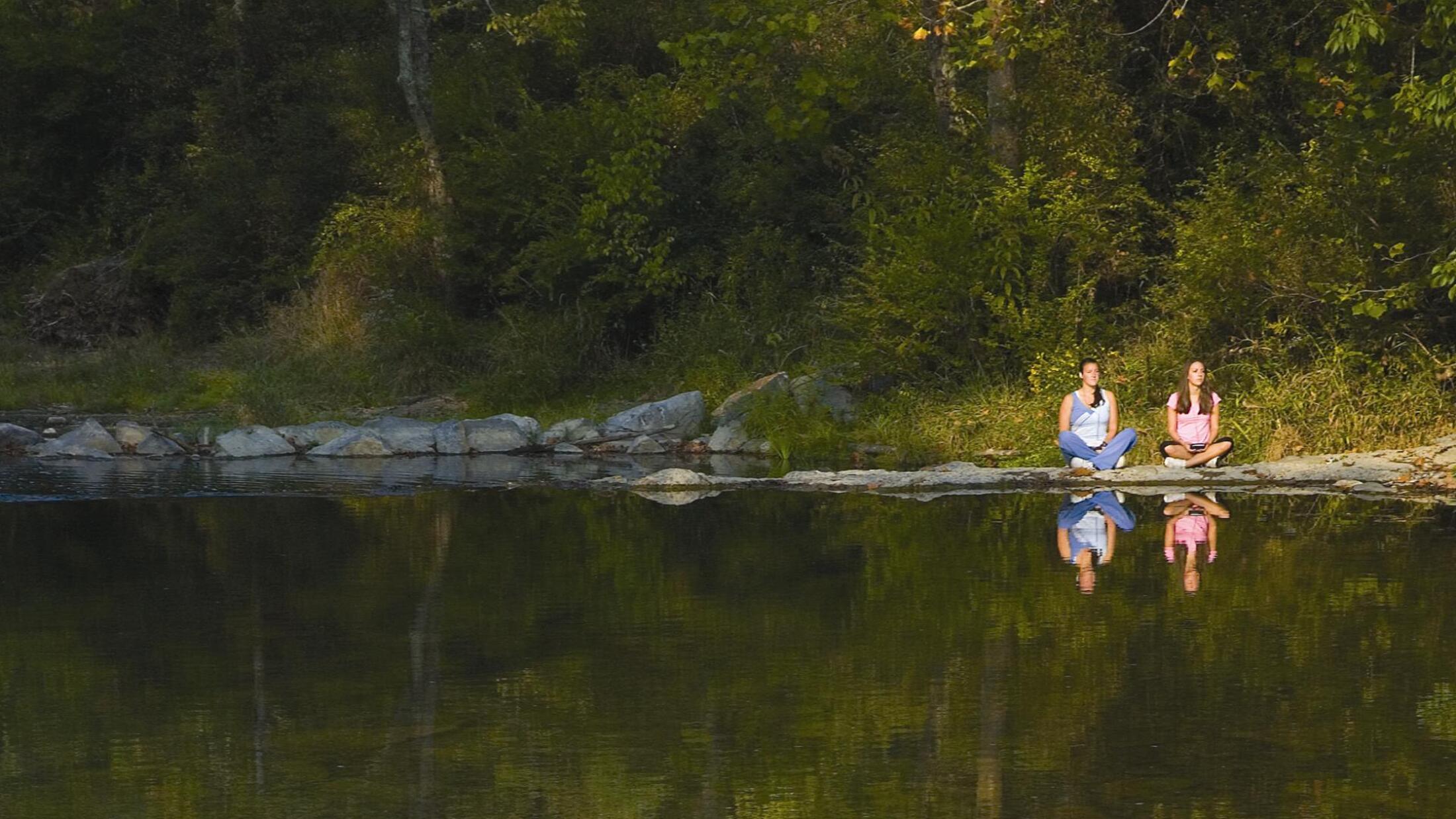 people-meditating-next-to-river